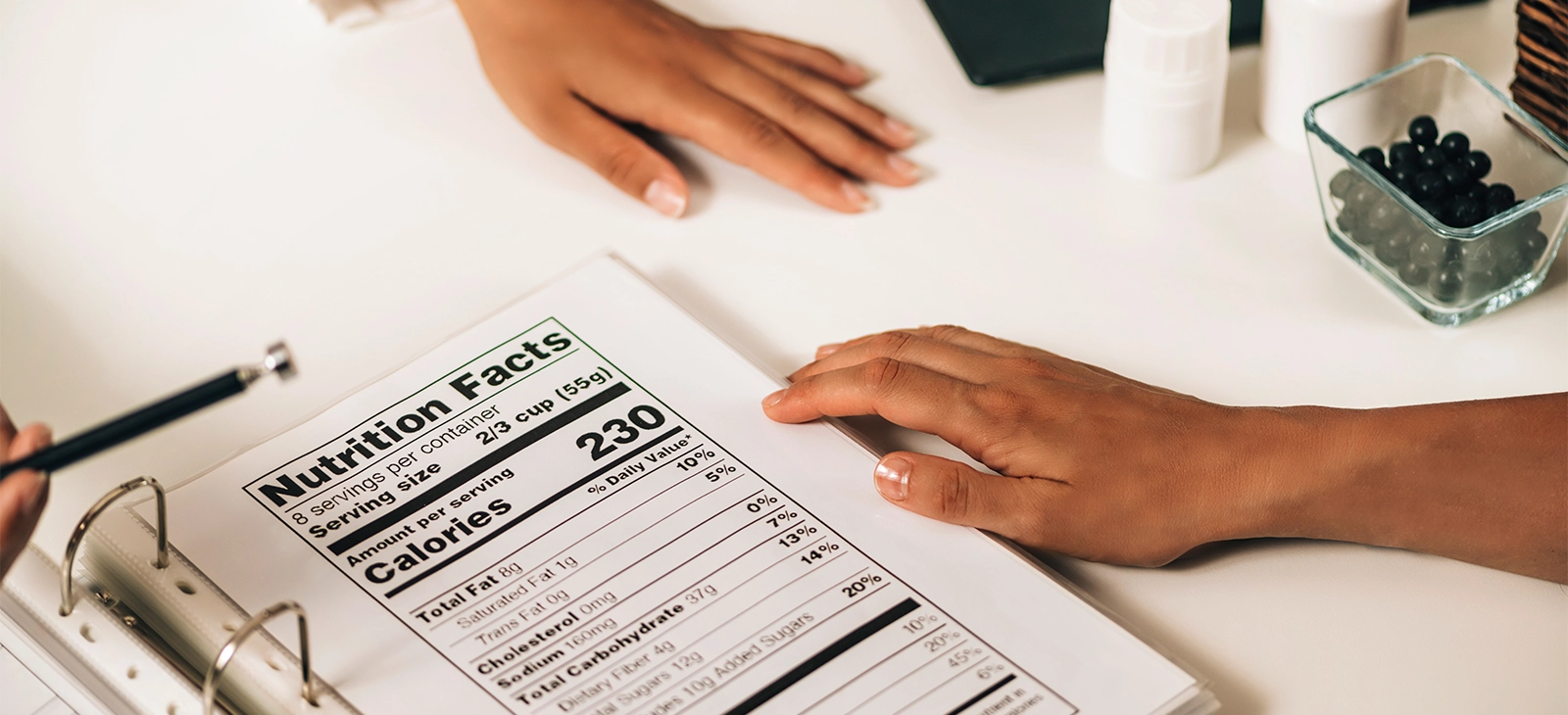 A nutrition facts label being discussed by two people.

