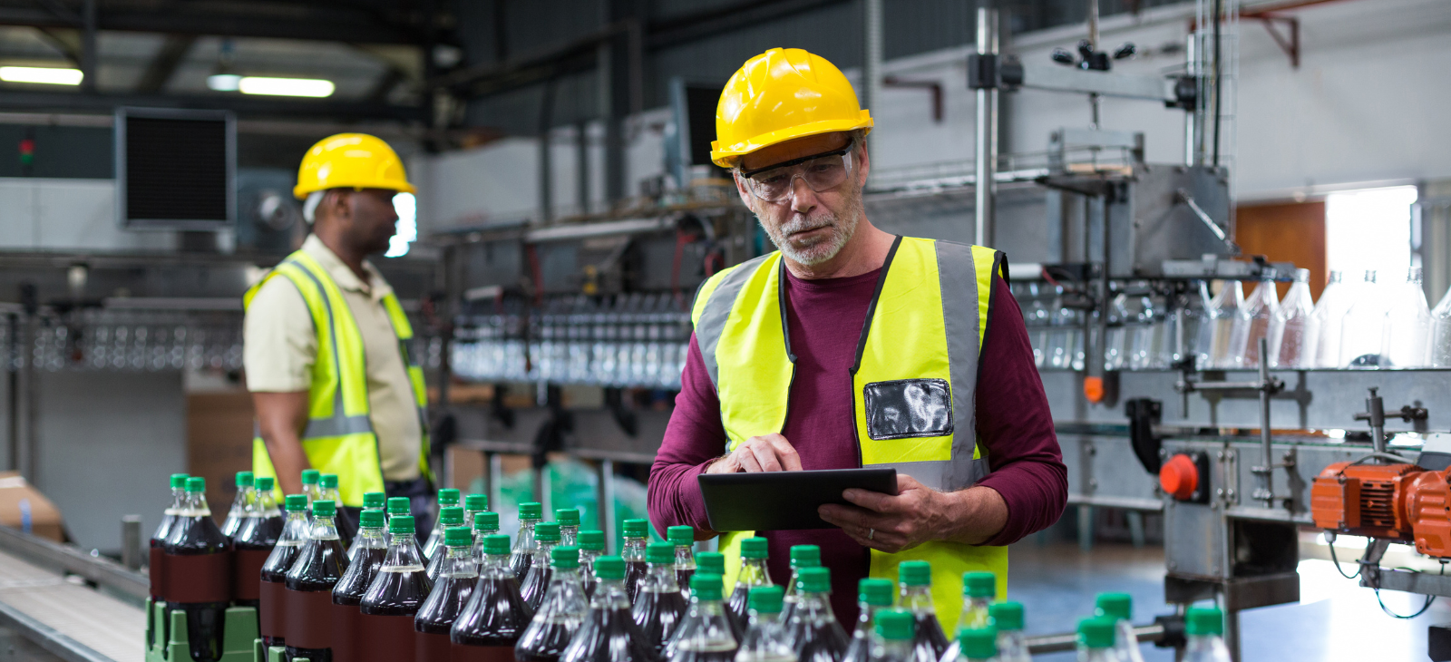 Factory Worker With Digital Tablet monitoring beverage